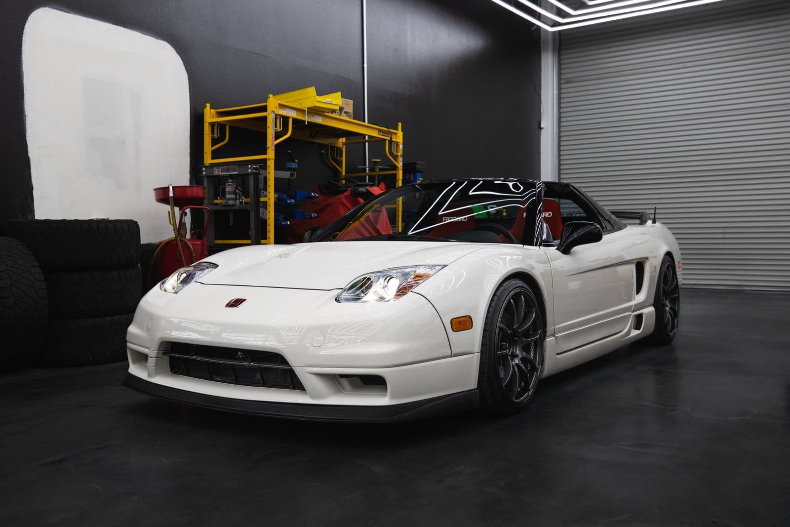 White sports car parked on a dark, glossy coated garage floor